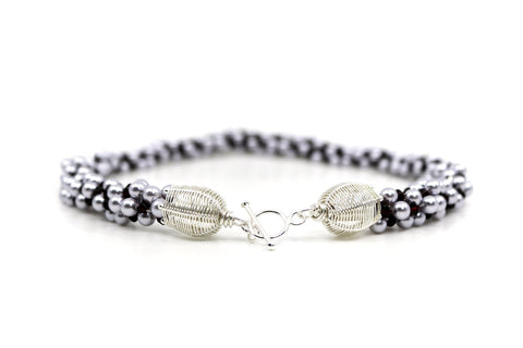 Royal necklace, 2022. Swarovski pearls and dark red crystals are braided into an elegant form using traditional Japanese kumihimo braiding. The clasp is made from woven sterling silver.