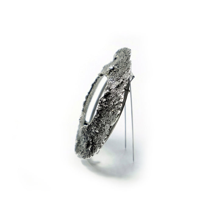 Sample-Collection Drill Hole Brooch in sterling silver, 14K yellow gold and stainless steel.