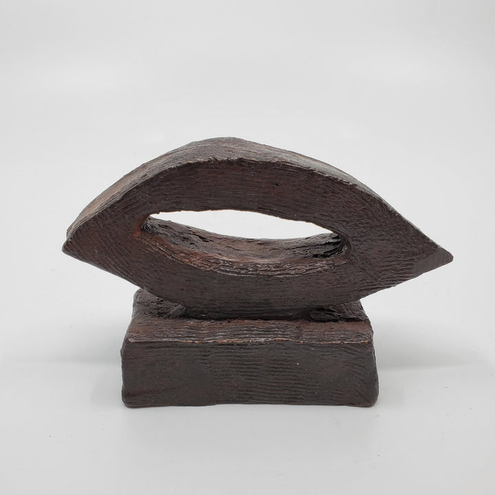 La Lumière sculpture in bronze. The minimalist shape of this piece is complimented by the ornate etching that covers the sculpture.   8 x 11 x 4 cm