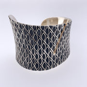 Sterling silver cuff adorned with a 18k gold bar motif with diamonds