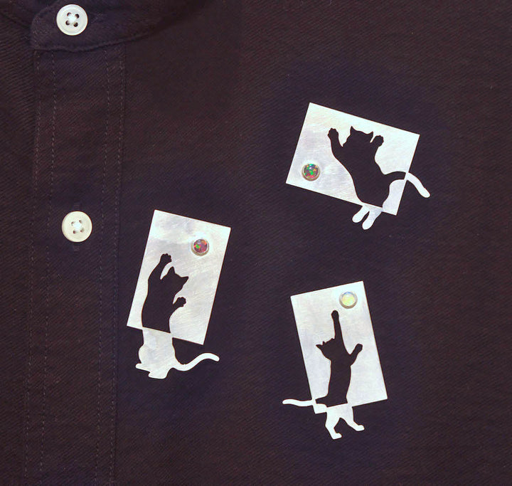 Sterling silver cut-out cats with synthetic opals. These playful pins have two locking pin backs. Sold separately. 
