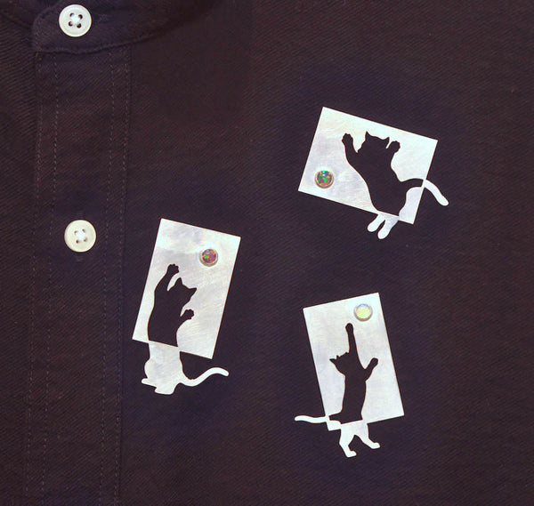 Sterling silver cut-out cats with synthetic opals. These playful pins have two locking pin backs. Sold separately. 