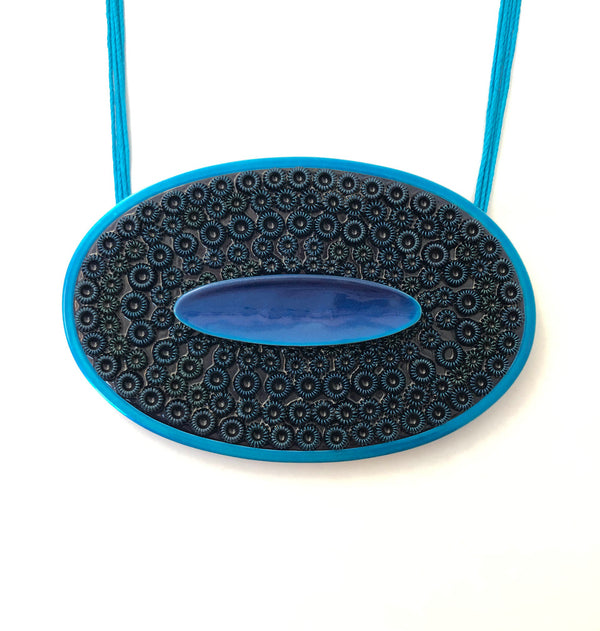 Oval Blue - necklace made from resin, textile and powder coated brass, copper, silver.  Pendant measures 12.3 cm wide x 8 cm high x 1.5 cm deep.
