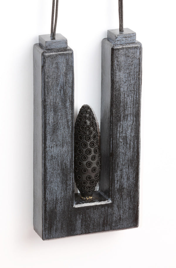 Suspension - necklace made from polyurethane, wood, polymer, powder coated, paint, fibre. Pendant measures 7 cm wide x 14 cm high x 2.3 cm 