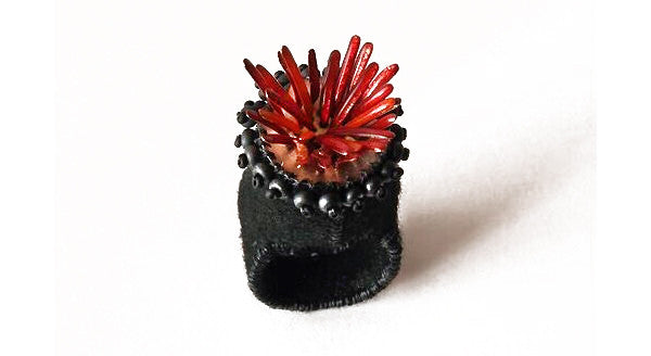 Black wool ring with silver, copper, and resin by Yael Krakowski.