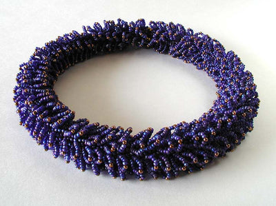 Blue and bronze Caterpillar Necklace with glass beads, and thread.