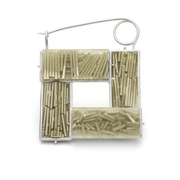 Brooch by Lydia Buxton in sterling silver, matcha, and resin. 