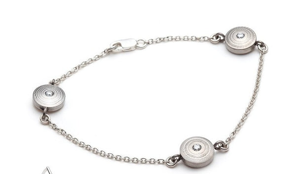 The Revolutio Collection. This bracelet is made from reclaimed titanium, taken from the waste bin of a titanium aerospace supplier and lab-grown diamonds. The textures are worked on a lathe. 12mm disks, 3 x 2.3mm diamonds